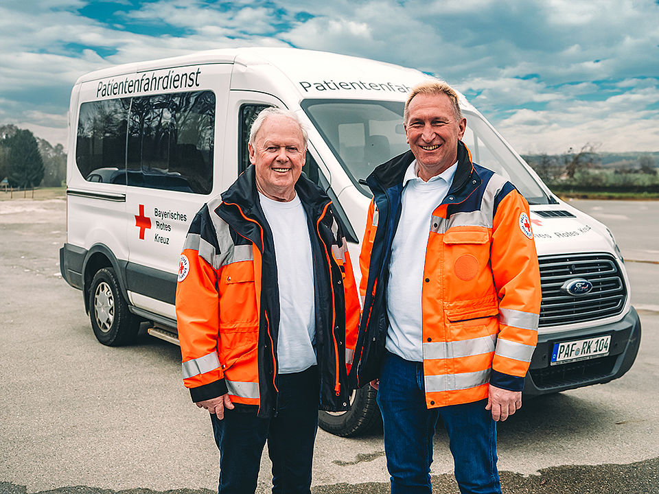 Fahrdienstleiter stehen vor Auto BRK Patientenfahrdienst